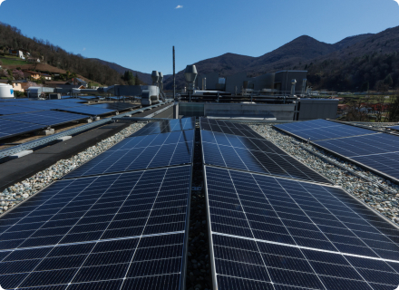 Solar panels on the roof of Microsphere's facility. Mountainous forests are present in the background.
